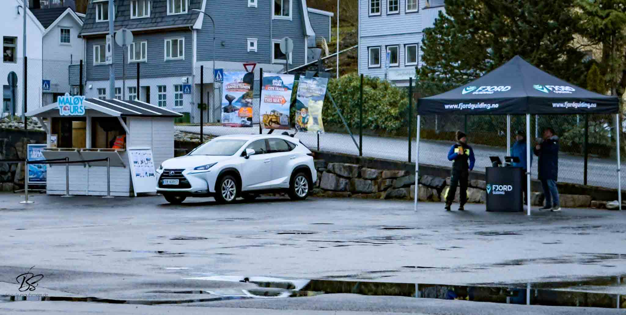 Local tour operator booth at Måløy harbour with excursion signs