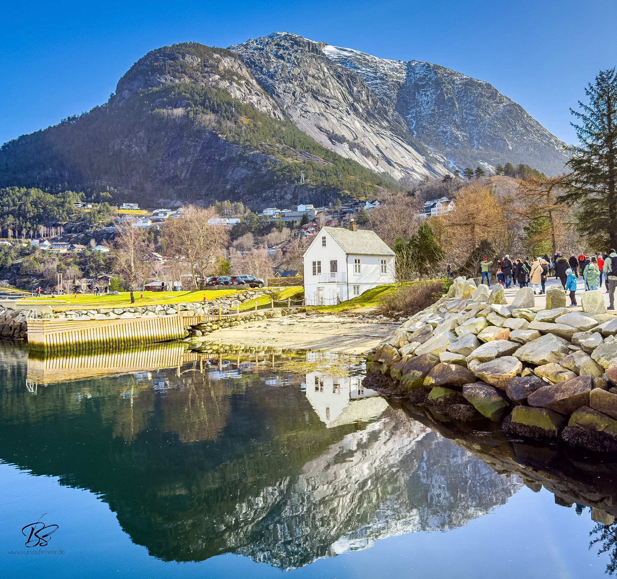 Eidfjord village waterfront and children playing by the shore in afternoon sun