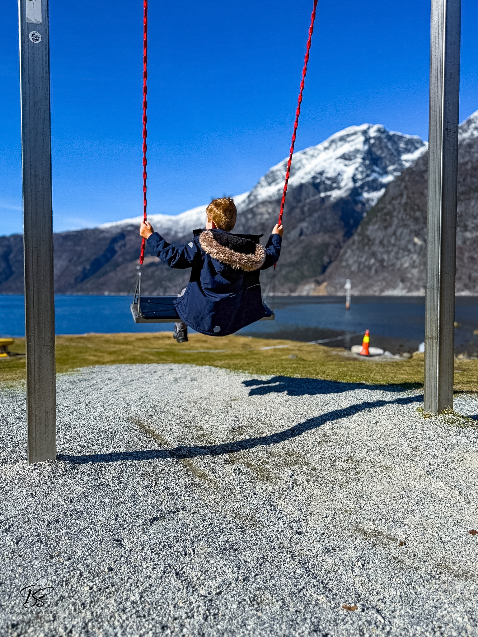 Eidfjord village waterfront and shoreline with children playing by the fjord